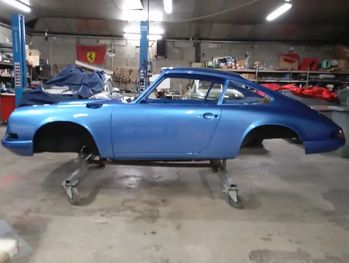 Porsche 911 bleue profil en atelier